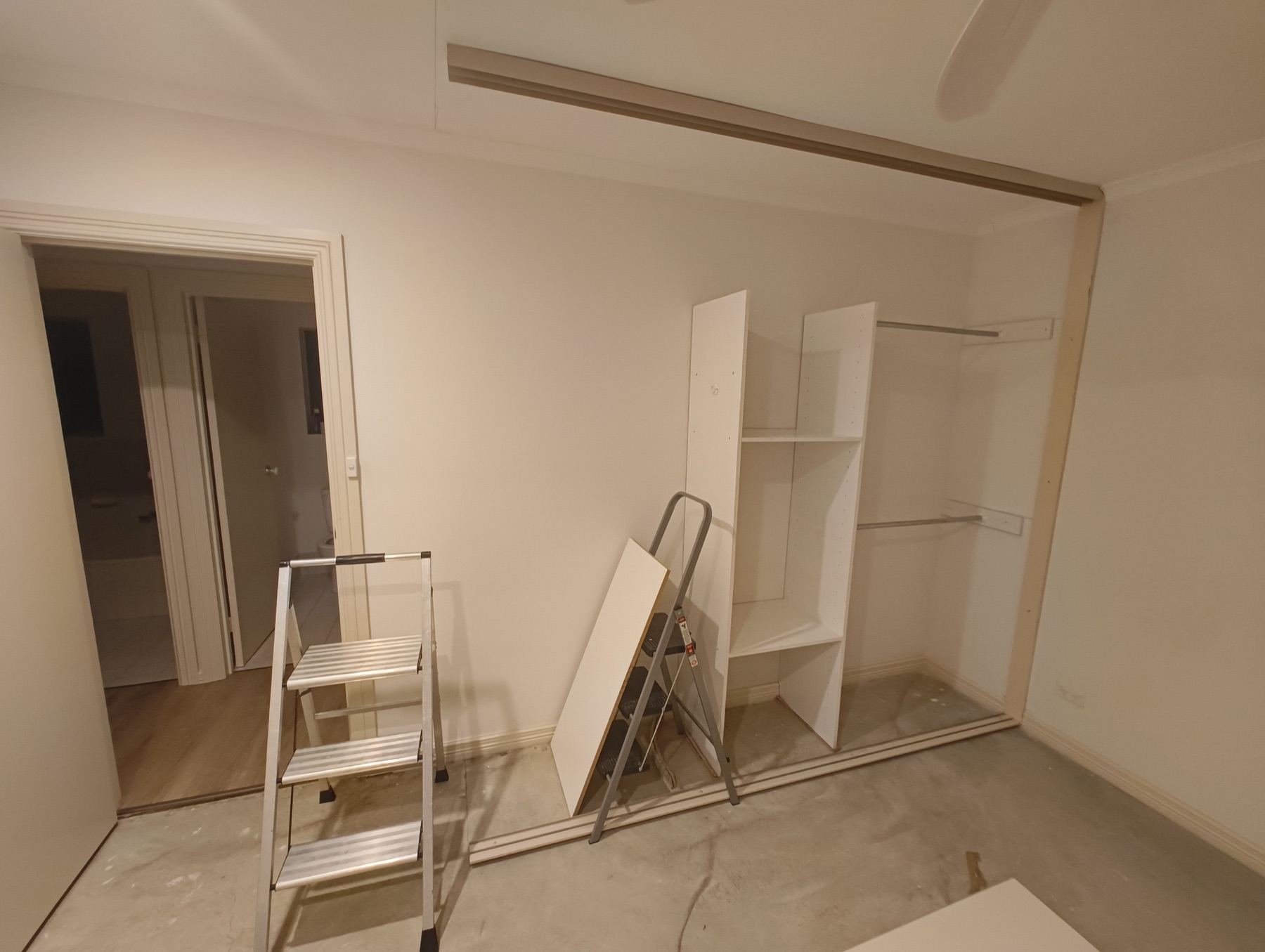 Walk-in wardrobe storage and sliding-door frame during installation