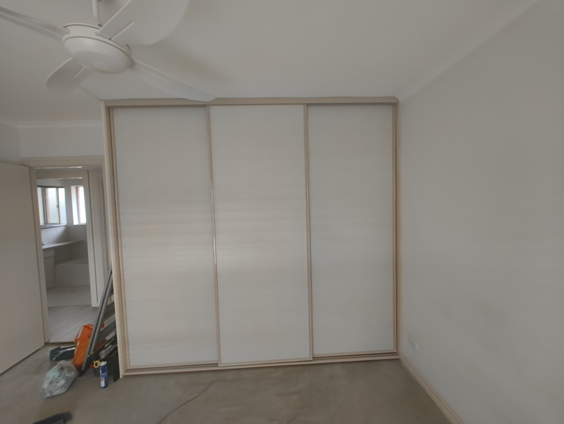 Completed walk-in wardrobe with three sliding doors